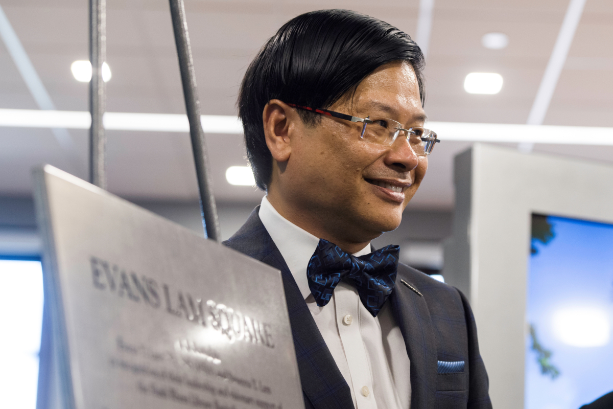 Evans Lam next to a plaque for Lam Square