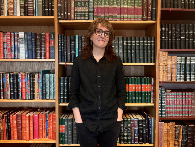 Anna Siebach-Larsen in front of a bookshelf in Robbins Library