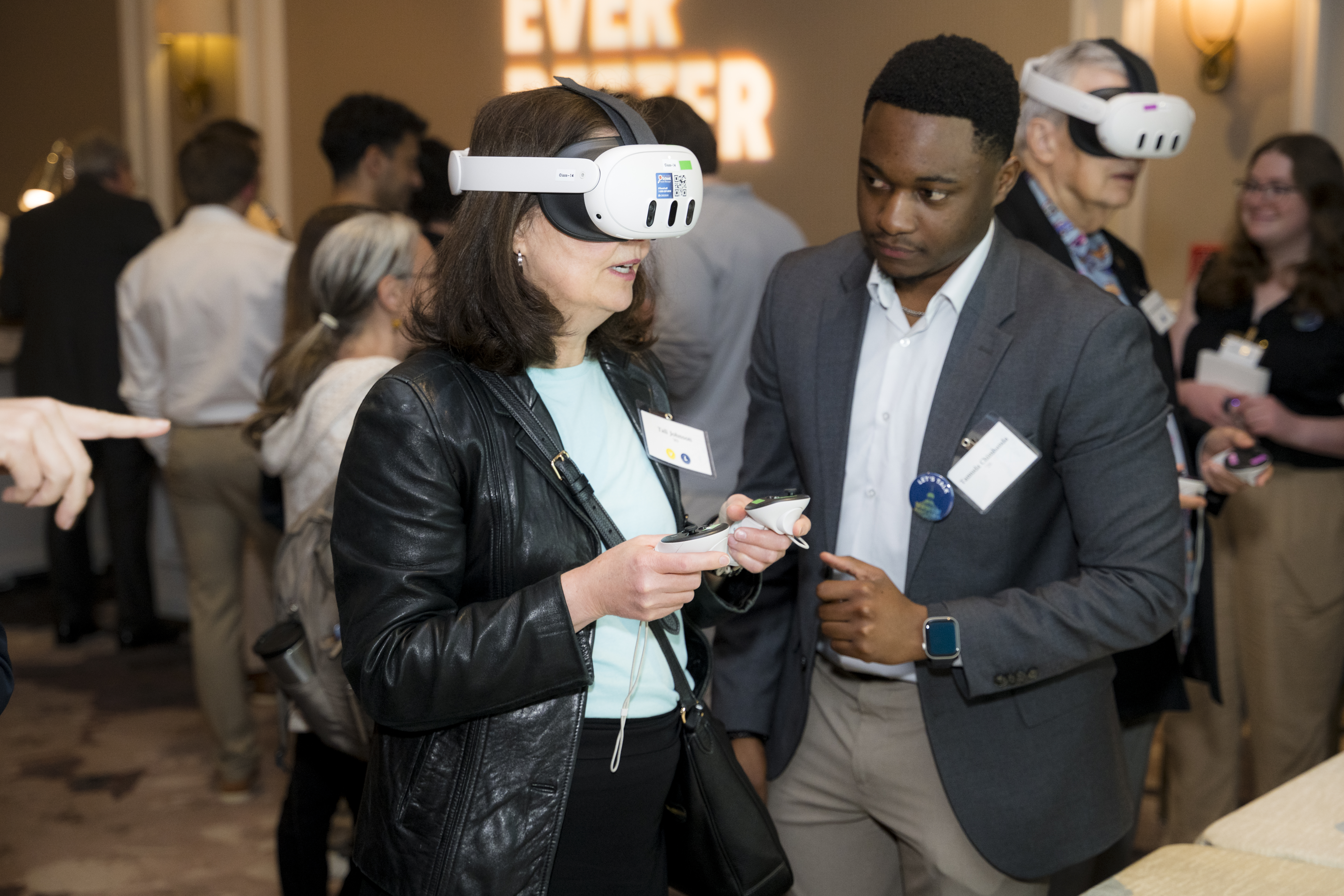 Tamuda helping an attendee try the VR application. 