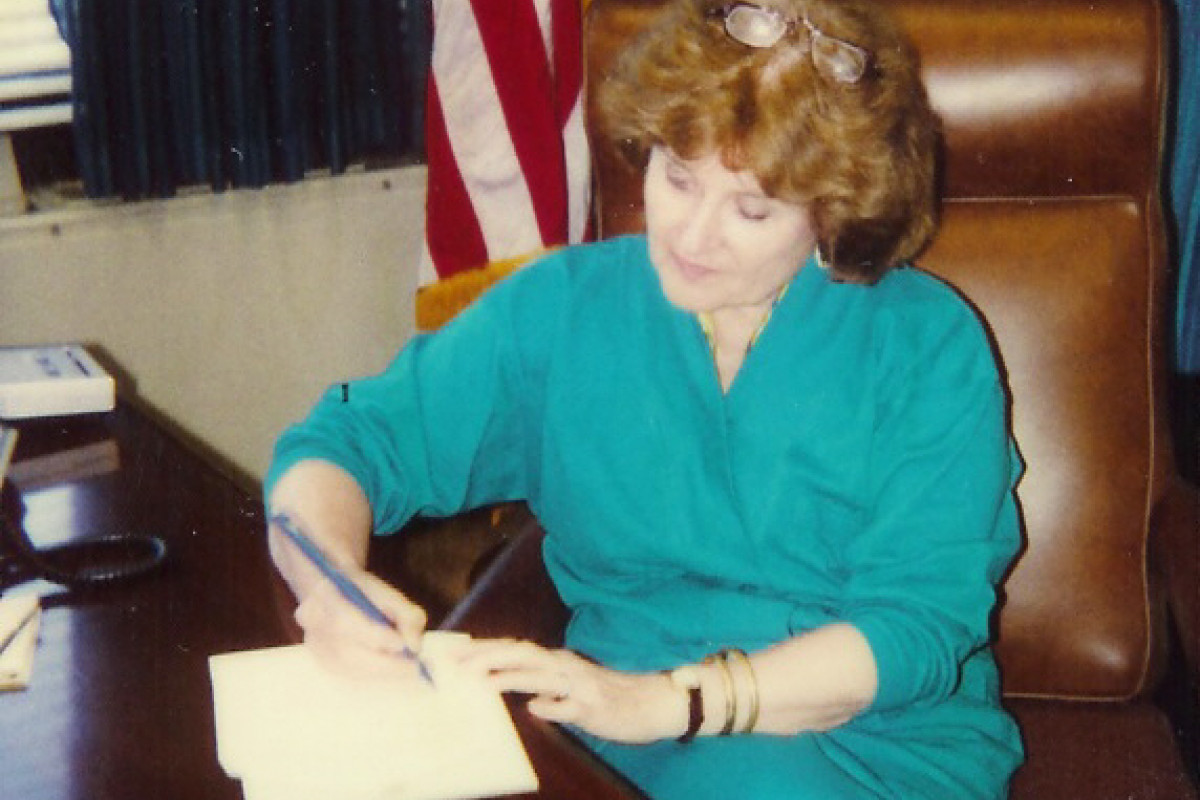 Congresswoman Louise Slaughter at a desk writing on a document