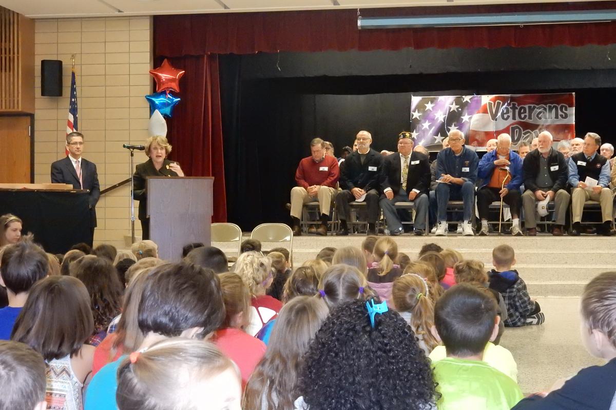 With war veterans behind her Congresswoman Louise Slaughter speaks to an assembly of elementary school kids