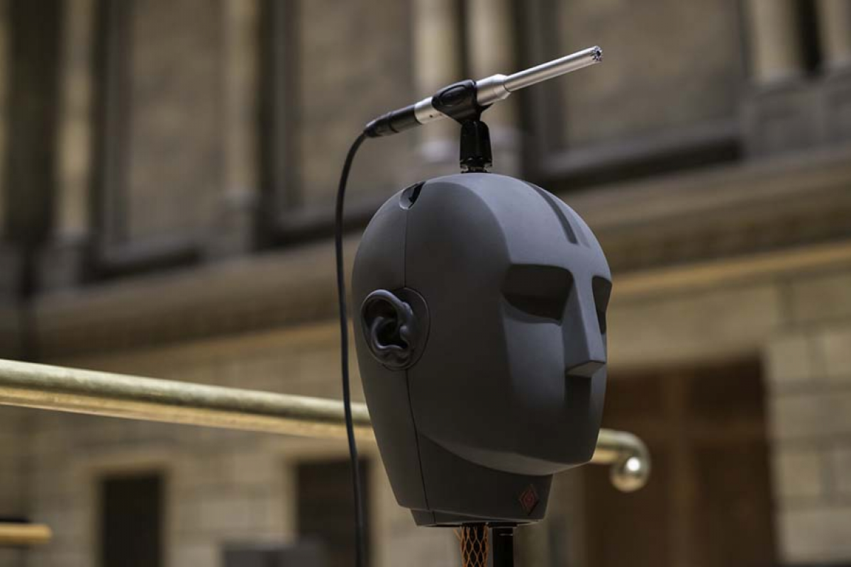 A dummy head on a stand with a microphone atop its head