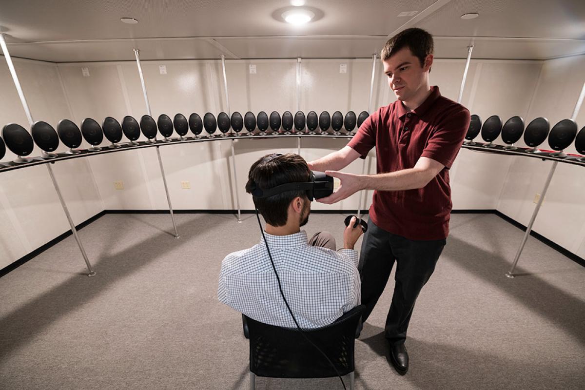 Biomedical engineering graduate student Tom Stoll, right, adjusts a virtual reality head-mounted display on assistant professor Ross Maddox. The array of speakers in Maddox's lab allows researchers to simulate realistic listening environments.	Biomedical engineering graduate student Tom Stoll, right, adjusts a virtual reality head-mounted display on assistant professor Ross Maddox. The array of speakers in Maddox's lab allows researchers to simulate realistic listening environments. (University photo / J. A