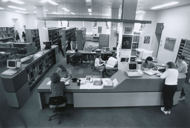 A black and white photo of the Rush Rhees Library's old reference desk which was in the space now occupied by Evans Lam Square