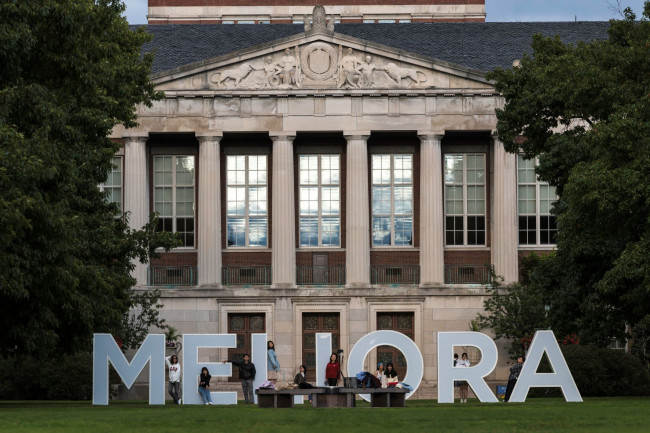 Large letter blocks spelling out MELIORA in front of Rush Rhees Library on the Eastman Quad