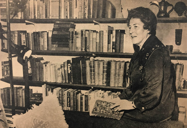 Ruth Missal seated by bookcase