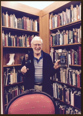 Lewis Neisner standing in front of bookcase