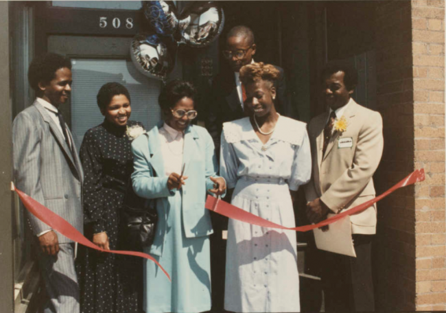 Ruth Scott cutting a ribbon for a ribbon cutting event for West Main Street Alliance
