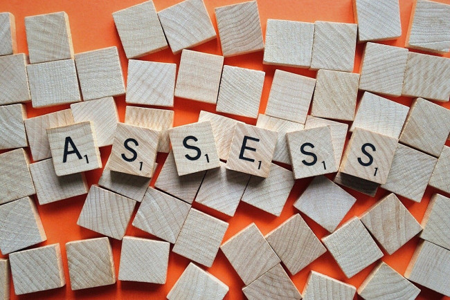Scrabble tiles that spell ASSESS