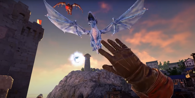 A gloved hand reaches for a blue dragon near a medieval tower at sunset.