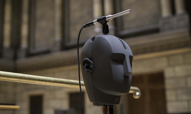 A dummy head on a stand with a microphone atop its head