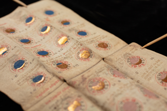 Medieval manuscript with gold and blue illuminations of solar and lunar eclipses