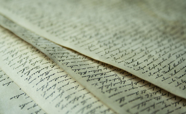 Old-looking pieces of paper that full of cursive writing