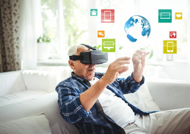 An elderly man with a VR headset sits beside a nurse.