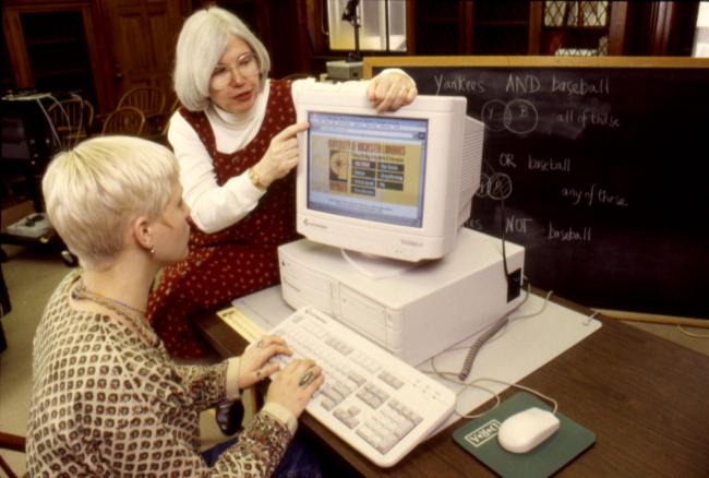 Judi Briden, Digital Librarian for Public Services atRush Rhees Library, and Lisa Peters ’97, look atthe library’s former system, Voyager, one of the library’s old Geac terminals, also known as “Chester.”