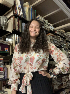 Photograph of Ayiana Crabtree, XR Research Fellow standing in the library